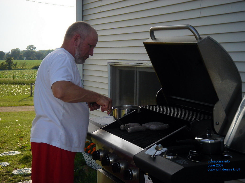 Gary checks the bratwurst on the grill