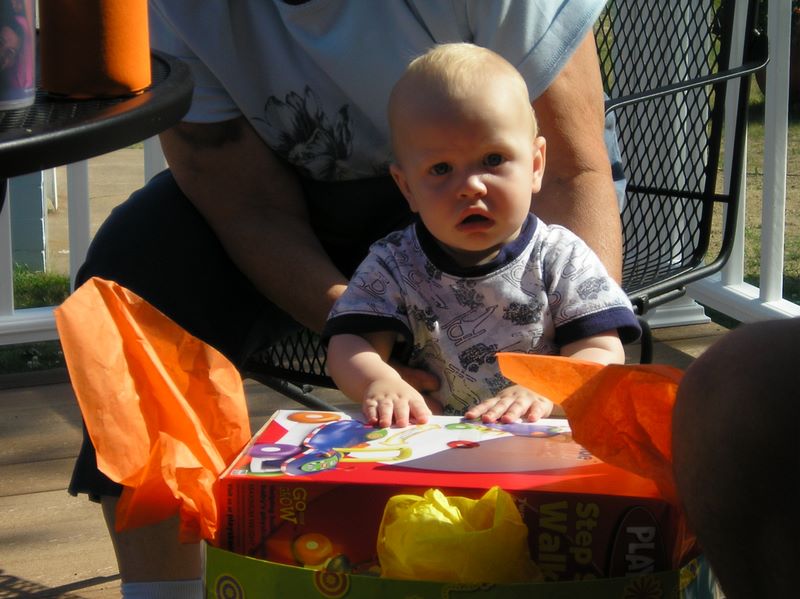 Closeup of Jared opening his first birthday gifts