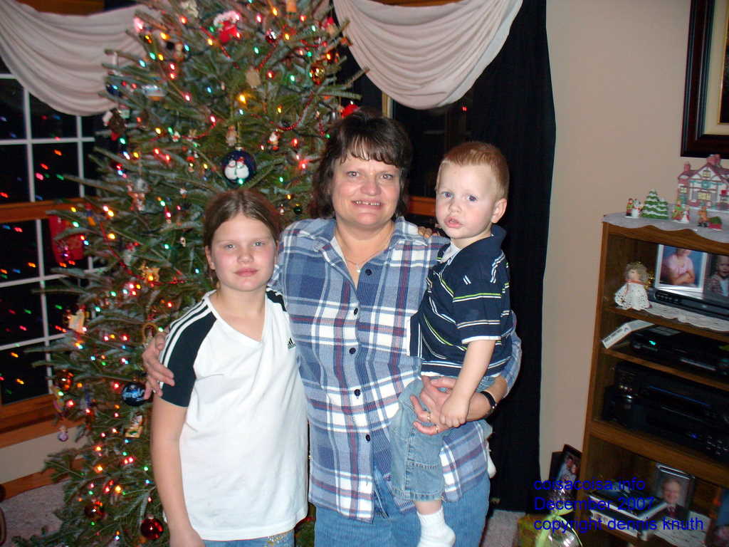 Kelsey, Sherri Donadean, and Jared in front of the Christmas Tree