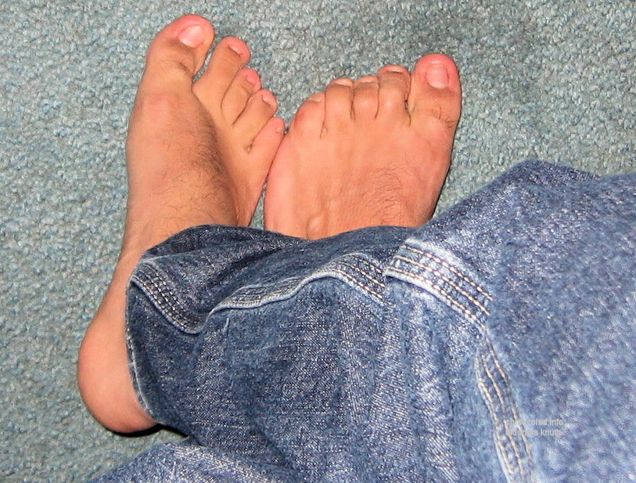 Sexy Man feet on Toes in Blue Jeans Denim on carpet