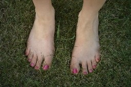 feet and toes on a grass lawn