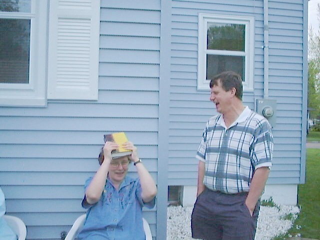 Nancy hiding under a book and Tom
