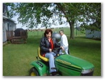 Rose is out of control mowing lawn while Emogene watches