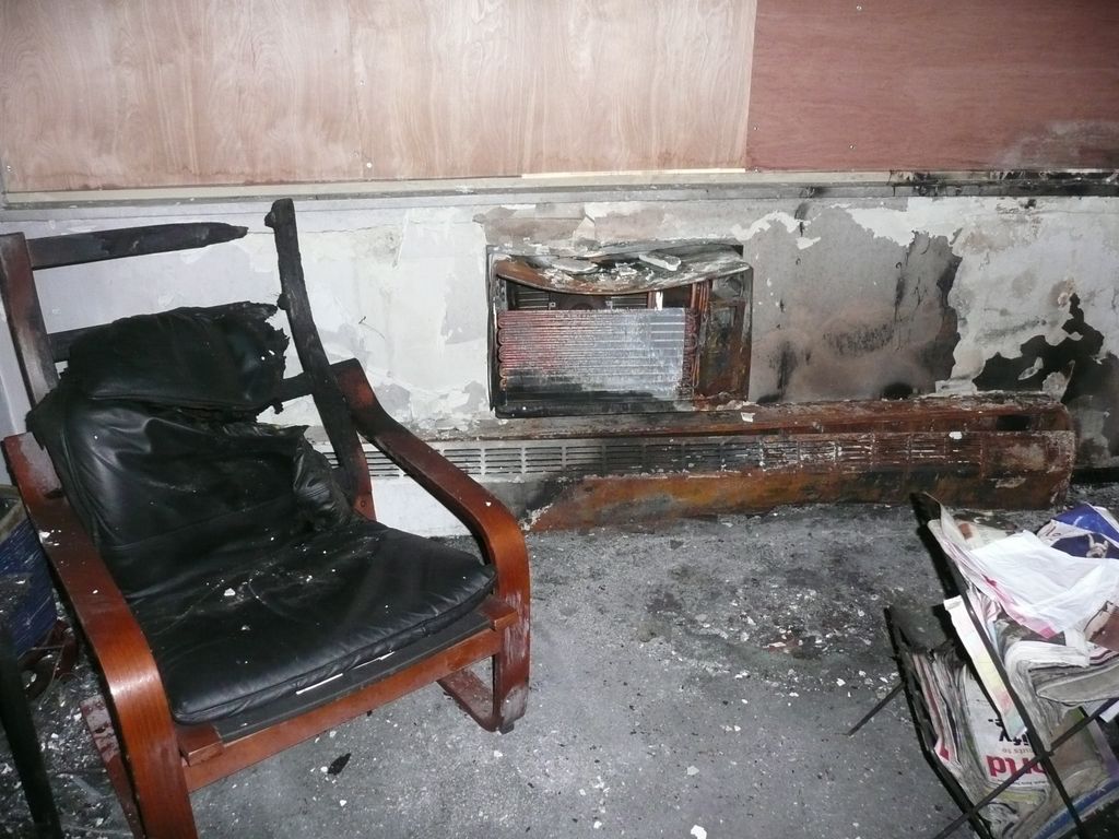 Boarded up windows and burned furnitue