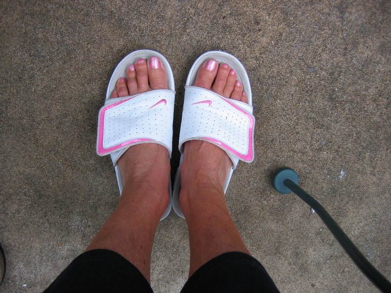 Beautiful woman's feet in Nike Sandals on a Carpet
